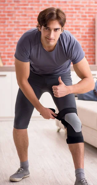 El joven guapo haciendo ejercicios deportivos en casa — Foto de Stock