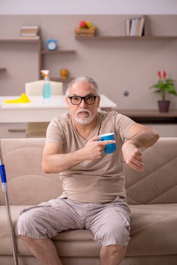 Evde ev işi yapan yaşlı bir adam.