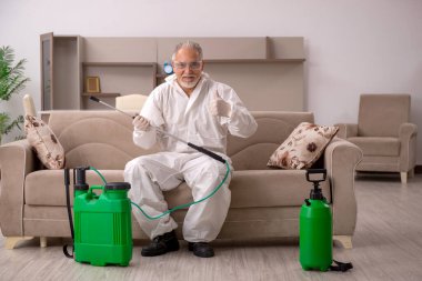 Yaşlı müteahhit evde haşere kontrolü yapıyor.