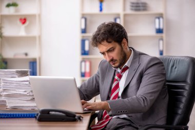 Genç işadamı ofisteki aşırı işten memnun değil.