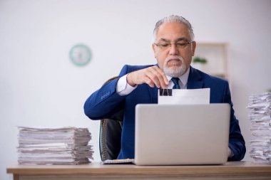Eski bir işadamı ve işyerinde çok fazla iş var.