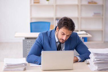 Genç işadamı ve ofiste çok fazla iş var.