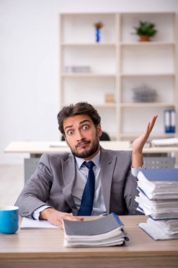 Genç işadamı ve ofiste çok fazla iş var.