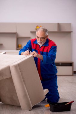 Evde çalışan yaşlı marangoz.