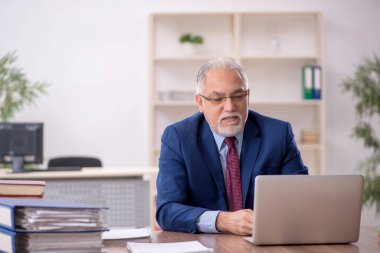 Ofiste çalışan eski bir işadamı.