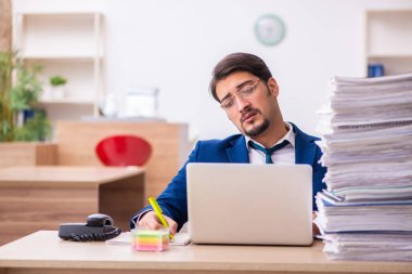 Genç işadamı ve ofiste çok fazla iş var.