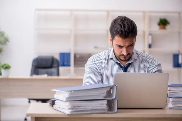 Young businessman employee and too much work at workplace