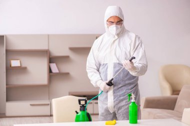 Genç müteahhit evde haşere kontrolü yapıyor.