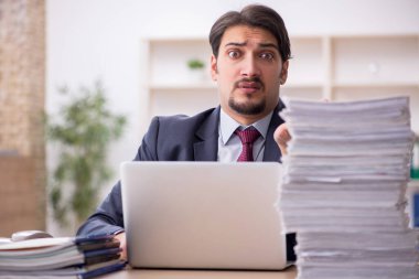 Genç işadamı işyerinde oturuyor.