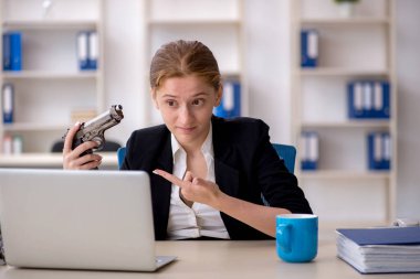 İş yerinde silah tutan kadın çalışan.