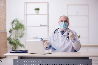 Klinikte çalışan yaşlı bir doktor.