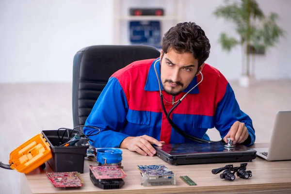 车间修理计算机的年轻修理工 — 图库照片