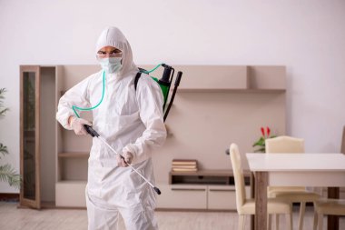 Genç müteahhit evde haşere kontrolü yapıyor.