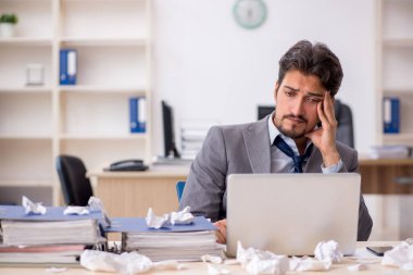 Genç bir çalışan ve ofiste çok fazla iş var.