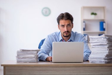 Genç işadamı ve ofiste çok fazla iş var.