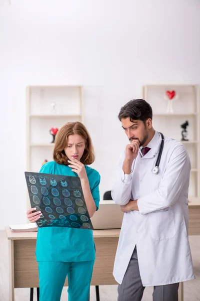 Young male doctor radiologist and female assistant working at the hospital