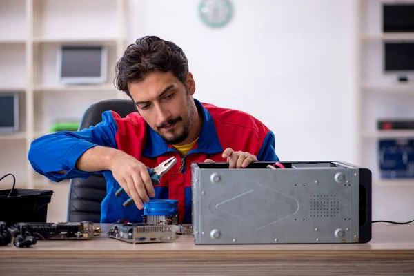 车间修理计算机的年轻修理工 — 图库照片