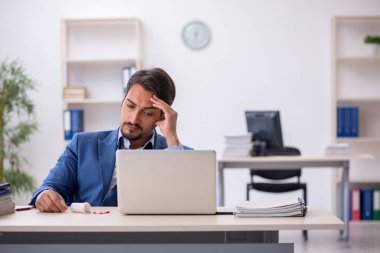 İş yerinde acı çeken genç bir işadamı