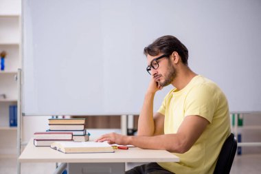 Sınıfta sınava hazırlanan genç bir öğrenci.