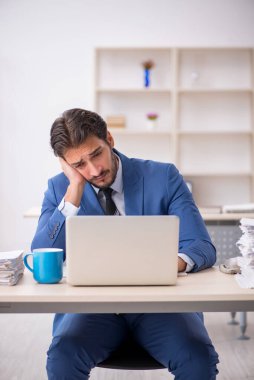 Genç işadamı ve ofiste çok fazla iş var.