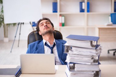 Genç işadamı ofisteki aşırı işten memnun değil.