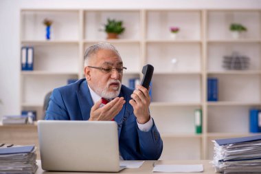 Ofiste çalışan eski bir işadamı.