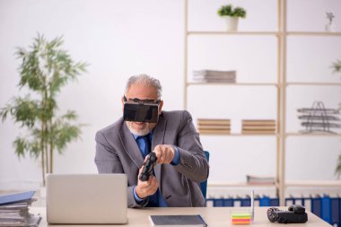 Eski işadamı ofiste sanal bardakların keyfini çıkarıyor.