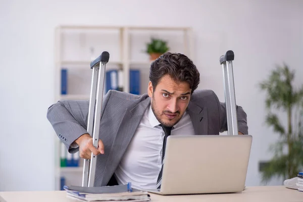 Young businessman employee after car accident working in the office