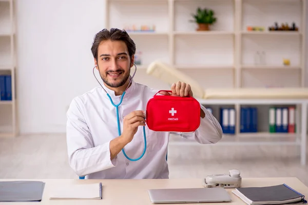 Young doctor paramedic holding bag
