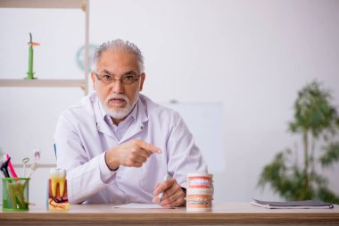 Klinikte çalışan yaşlı bir dişçi.