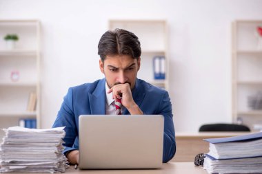 Genç işadamı ve işyerinde çok fazla iş var.