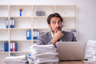 Genç işadamı ve ofiste çok fazla iş var.
