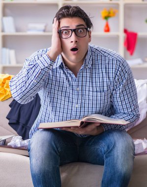 Dağınık odada çalışan genç adam.