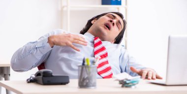 Ofiste acı çeken genç bir erkek işçi.