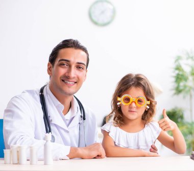 Küçük bir kızla birlikte genç doktor çocuk doktoru.