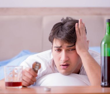 Yatakta içen alkolik adam depresyona giriyor.