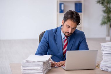 Genç işadamı ve ofiste çok fazla iş var.