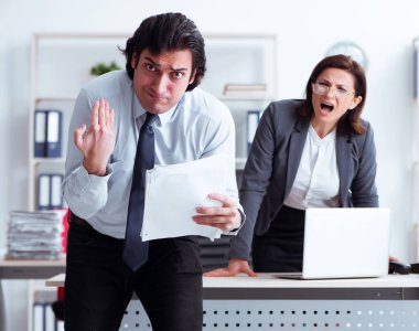 Yaşlı kadın patron ve genç erkek çalışan ofiste.