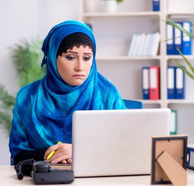 Ofiste çalışan tesettürlü kadın çalışan.