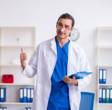Klinikte çalışan genç erkek doktor.