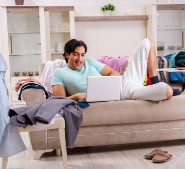 Genç adam evde ütü yapıyor.