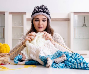 Evde örgü ören genç ve güzel kadın.