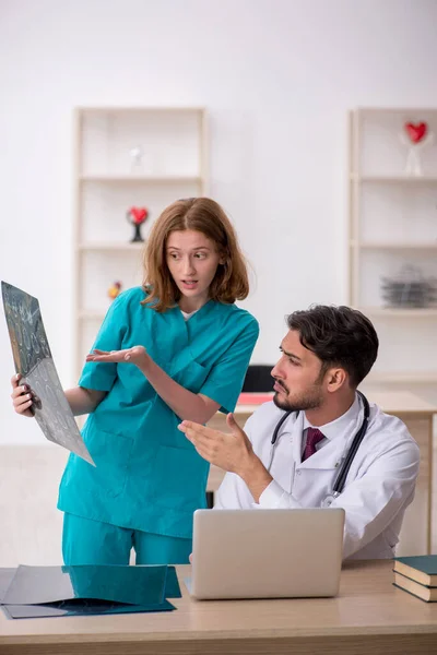 Young male doctor radiologist and female assistant working at the hospital