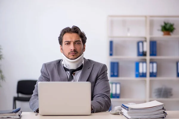 Young businessman employee after car accident working in the office