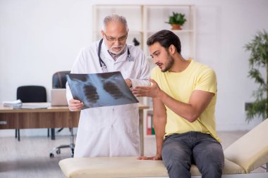 Genç doktor yaşlı doktoru ziyaret ediyor.