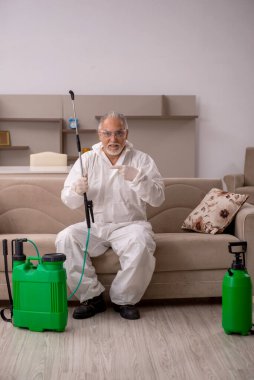 Yaşlı müteahhit evde haşere kontrolü yapıyor.