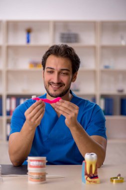 Klinikte çalışan genç bir dişçi.