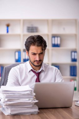 Genç işadamı ve ofiste çok fazla iş var.