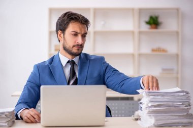 Genç işadamı ve ofiste çok fazla iş var.