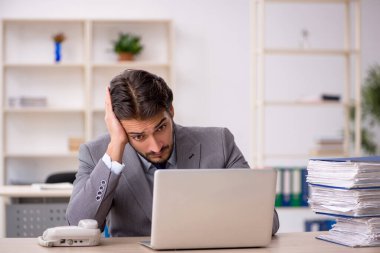 Genç işadamı ve ofiste çok fazla iş var.